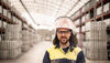 Oskar Rundberg, operator at Stena Aluiminium’s smelter, dressed in hi-vis protective gear, standing in the facility where aluminium ingots are stored. 