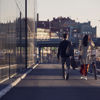 Two pedestrians – one wheeling a bicycle – walk together in Gothenburg, Sweden.