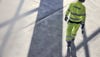 A rear shot of a Stena Metall Group employe wearing hi-vis gear and a protective hard hat.
