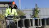 A male Stena Stål employee in hi-vis protective gear, standing beside steel beams, with a measurement device in one hand.